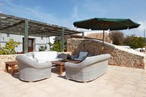 patio z 2 krzesłami i stołem z parasolem w obiekcie Can Mariano w mieście Ibiza