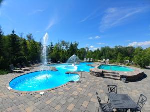 a swimming pool with a fountain in a patio at Cap Tremblant Mountain Resort in Mont-Tremblant