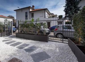 a fence in front of a house with parked cars at Le bougainvillea 1 in Corbetta