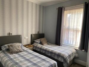 um quarto com duas camas e uma janela em Inglewood Guest House em Sandown