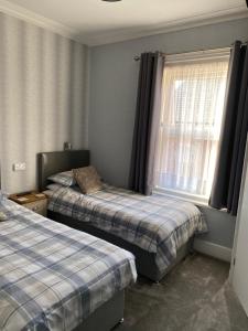 a bedroom with two beds and a window at Inglewood Guest House in Sandown