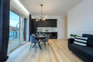 a living room with a table and a couch at Marina Glamour - 3pok, widok na jezioro, klimatyzacja, parking podziemny, winda, Netflix in Iława +26 photos