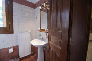 bagno con lavandino e porta in legno di Mirtillo Apartments a Kissós