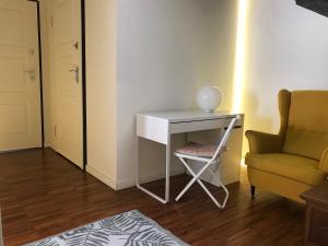 a small white desk with a chair and a couch at Sweet & cosy room next to the beach in Viareggio