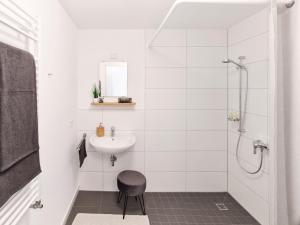 a white bathroom with a sink and a shower at Design Apartment Stuttgart Messe-Airport Tiefgarage in Leinfelden-Echterdingen