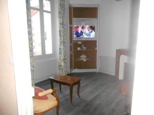 - un salon avec une table et une télévision dans l'établissement MAISON EN VILLE, à Airvault