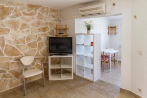 - un salon avec une télévision et une table avec des chaises dans l'établissement Apartments Kaktus Orebic, à Orebić