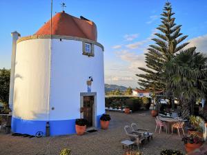 ein kleines Gebäude mit einem Kreuz darüber in der Unterkunft Moinho do Marco in Setúbal