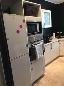 a white refrigerator in a kitchen with a microwave at Apartament w Domku in Gdynia