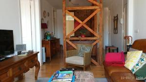 salon z kanapą i drewnianymi drzwiami w obiekcie Casa do Passadiço w Lizbonie