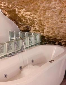 La salle de bains est pourvue d'une baignoire avec un robinet. dans l'établissement Apartamentos3Cuevas, à Setenil de las Bodegas