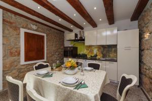 Grižane的住宿－Barac Rural Holiday Home，厨房以及带桌椅的用餐室。