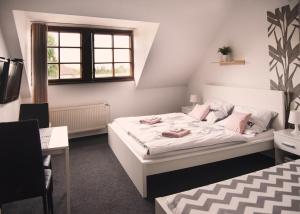 una camera con letto, scrivania e finestra di Guesthouse Zlatý Hrozen a Česká Lípa