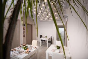 a dining room with white tables and a plant at Roof Garden in Salerno