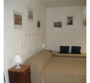 a bedroom with a bed and two lamps and pictures on the wall at Venice Home in Venice