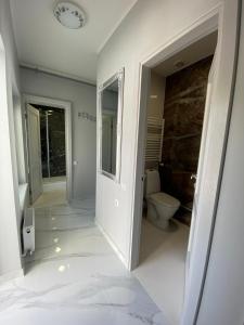 La salle de bains blanche est pourvue de toilettes et d'une fenêtre. dans l'établissement Jurmala Guest House Markiza, à Jurmala