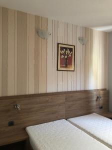 ein Schlafzimmer mit 2 Betten und einem Bild an der Wand in der Unterkunft Hotel Holiday in Eforie Nord