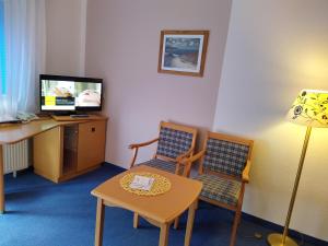 a room with a desk and two chairs and a table at Hotel Faller in Breitnau