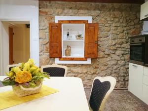 una cucina con tavolo e vaso di fiori di Barac Rural Holiday Home a Grižane