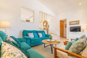 Una sala de estar con un sofá azul y una mesa. en Villa Noelia, en Santo Tomás