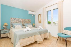 1 dormitorio azul con 1 cama y 1 silla en Villa Noelia en Santo Tomás