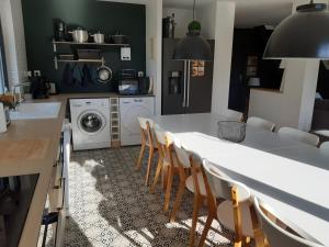 uma cozinha com uma mesa e cadeiras e uma máquina de lavar roupa em LES TERRASSES 1 de VILLARD em Villard-de-Lans