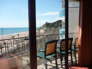 a room with a balcony with a view of the beach at Hotel Haromar in Calella