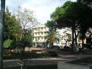 un parco con panchine e alberi e un edificio di Hotel Tirreno a Sapri