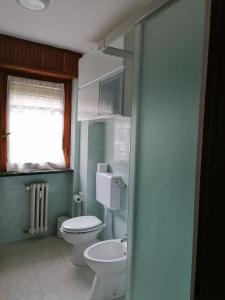 a bathroom with a white toilet and a sink at Courma House in Courmayeur