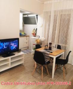salon ze stołem i telewizorem w obiekcie Giuly'S House Cozy & Comfy Apartment in Rome ....Real Rome !!! w Rzymie