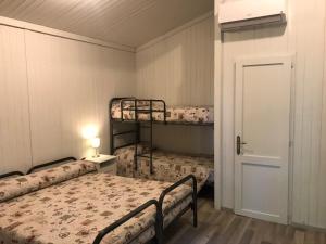 Zimmer mit 2 Etagenbetten und einer Tür in der Unterkunft Anthares World Resort in Candia Canavese