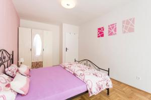 sypialnia z łóżkiem z fioletowym kocem w obiekcie Apartment Aquamarine w Rabacu