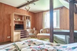 1 dormitorio con 1 cama, TV y mesa en Vila Poilsis Nidoje en Nida