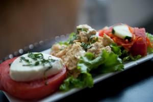 a plate of food with a salad and a tomato at Z Ocean Hotel, Classico A Sonesta Collection in Miami Beach