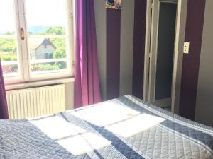 a bedroom with a bed in front of a window at Le Relais des 5 Chateaux in Vézac