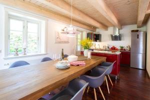 a kitchen with a wooden table and blue chairs at Reetdachhaus Skagen in Nebel