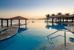 a swimming pool with a view of the ocean at Hotel Nacional Inn Angra dos Reis in Angra dos Reis