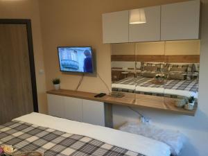 una stanza con due letti e una TV a parete di Your Place Apartment a Varna