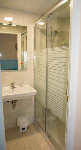 uma casa de banho com uma cabina de duche em vidro e um lavatório. em Hostal Empordà em Castelló d'Empúries