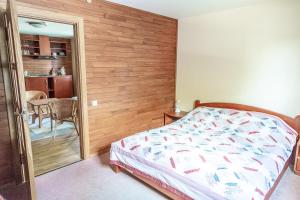 1 dormitorio con 1 cama y pared de madera en Vila Poilsis Nidoje, en Nida