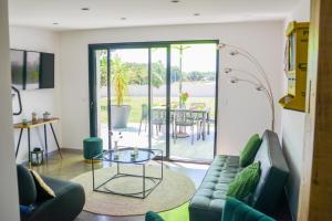 a living room with a couch and a glass table at détente et confort - gite baie bocage in Sartilly