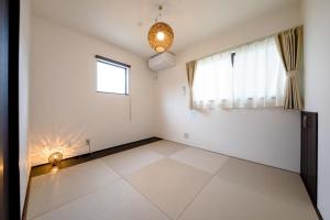 een witte kamer met een raam en een tegelvloer bij Minamitsuru-gun - House - Vacation STAY 82405 in Fujikawaguchiko