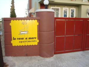 a gate with a sign on it next to a house at La casa a mare in Artemida