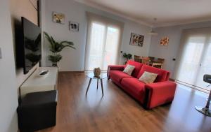 uma sala de estar com um sofá vermelho e uma mesa em Apartamento Capri Los Boliches Wifi gratis Beach 100m em Fuengirola