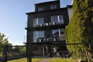 a black house with chairs on the balcony at LULU Władysławowo - Tanie Pokoje Gościnne Bike & Surf Friendly in Władysławowo