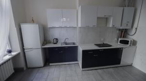 a small kitchen with a refrigerator and a microwave at Family Hostel Lviv in Lviv +14 photos