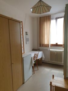 a room with a kitchen and a table and a refrigerator at Pension Engel in Pfullendorf