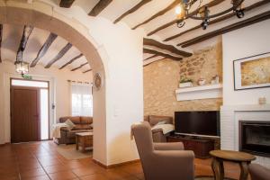 sala de estar con TV y chimenea en Casa Amparo - Alquiler íntegro con encanto en Alicante, en Alcoleja