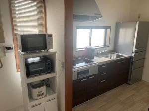 una pequeña cocina con fregadero y microondas en Sado - Hotel - Vacation STAY 82495 en Sado