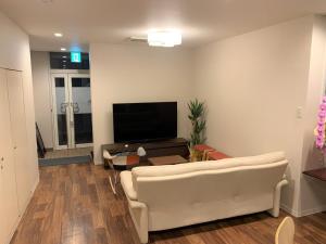 sala de estar con sofá blanco y TV de pantalla plana en Sado - Hotel - Vacation STAY 82495, en Sado
